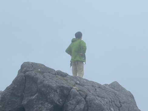 黒ボコ岩に一人たたずむリーダー。背中で語る。