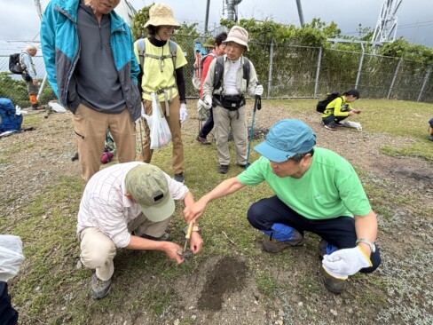 烏ケ岳の山頂で、土壌調査のサンプルを採取中。土遊びではないよ(>_<)